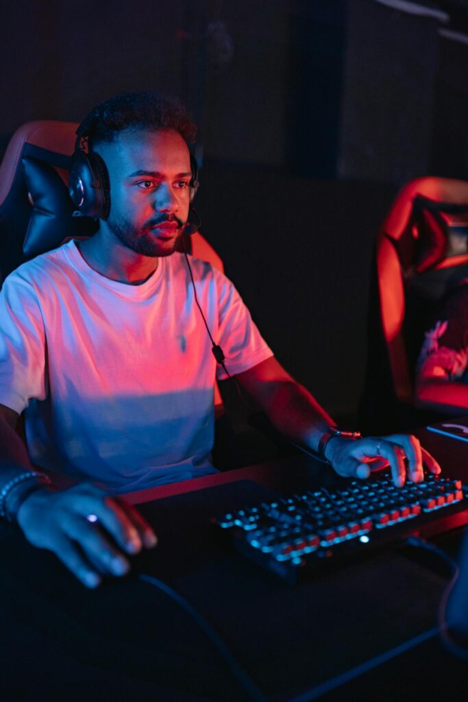 A dedicated gamer using a headset and keyboard during an intense online tournament.